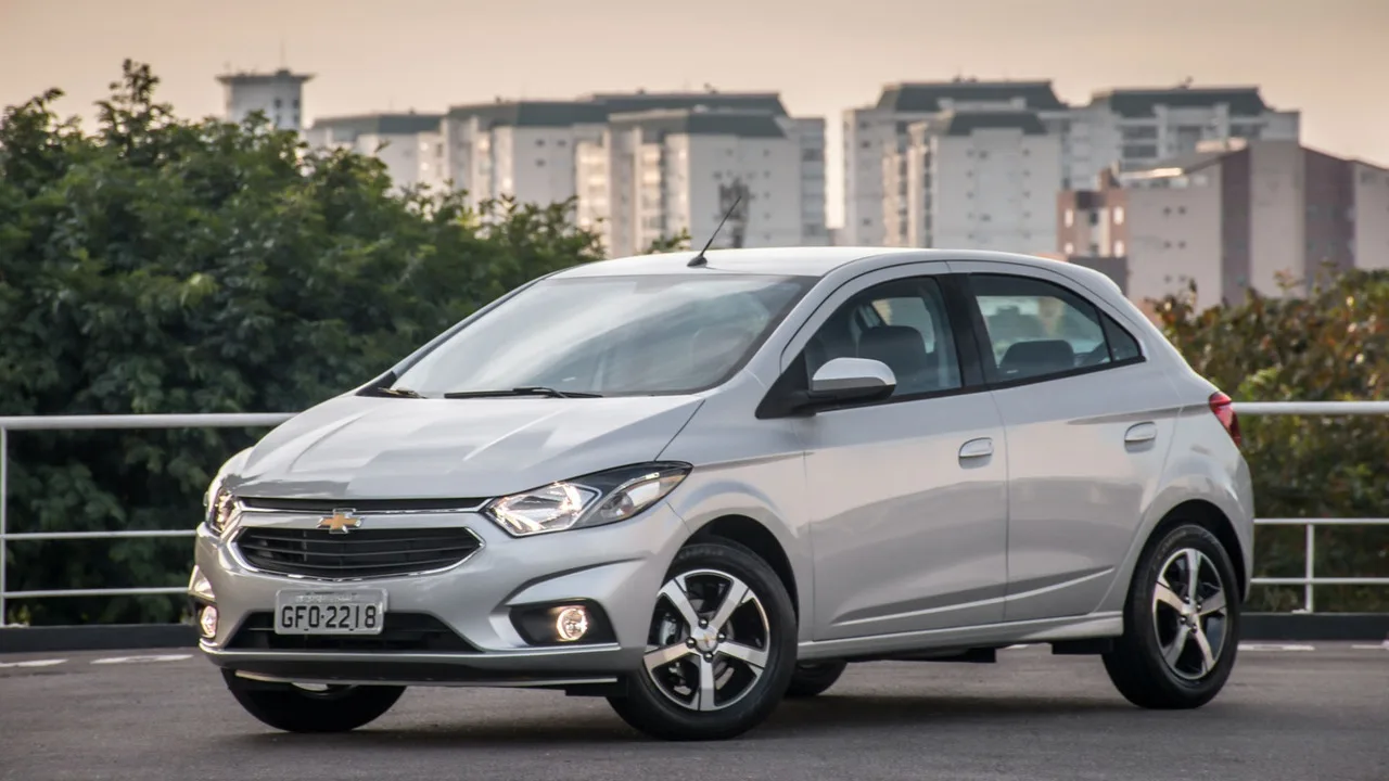 Chevrolet Onix prateado estacionado em área urbana — imagem ilustrativa do modelo